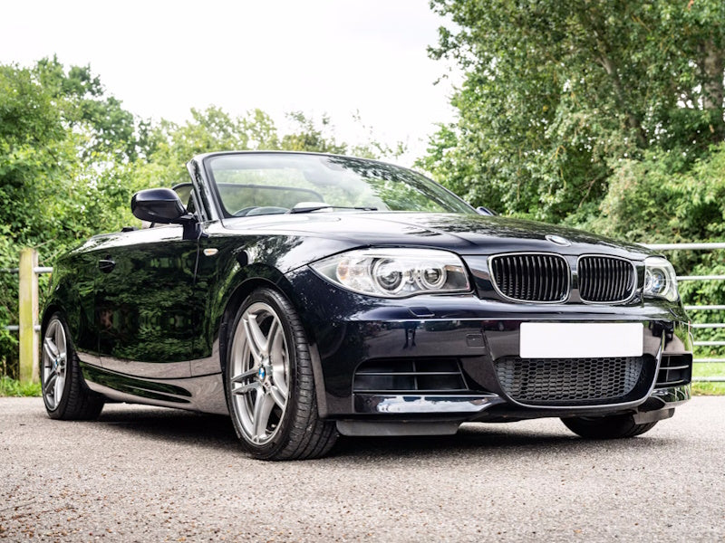 Black convertible car parked on a road.