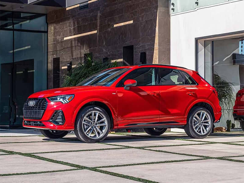 Red Audi SUV parked outside a building.