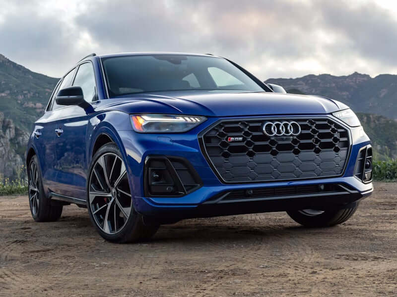 Blue Audi SUV parked on dirt road.