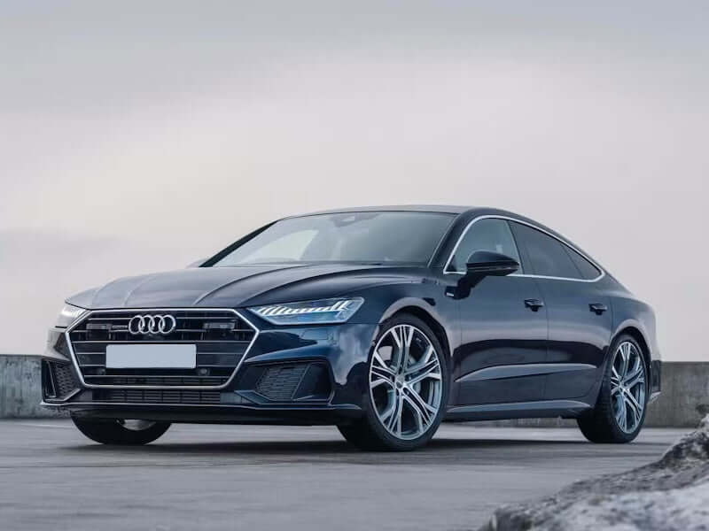 Dark blue Audi sedan on a concrete surface.