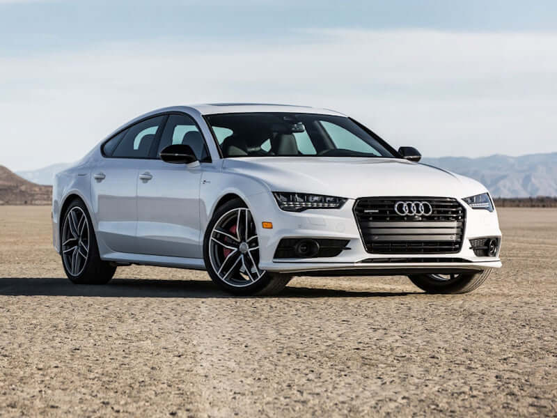 White Audi sedan on dirt road.