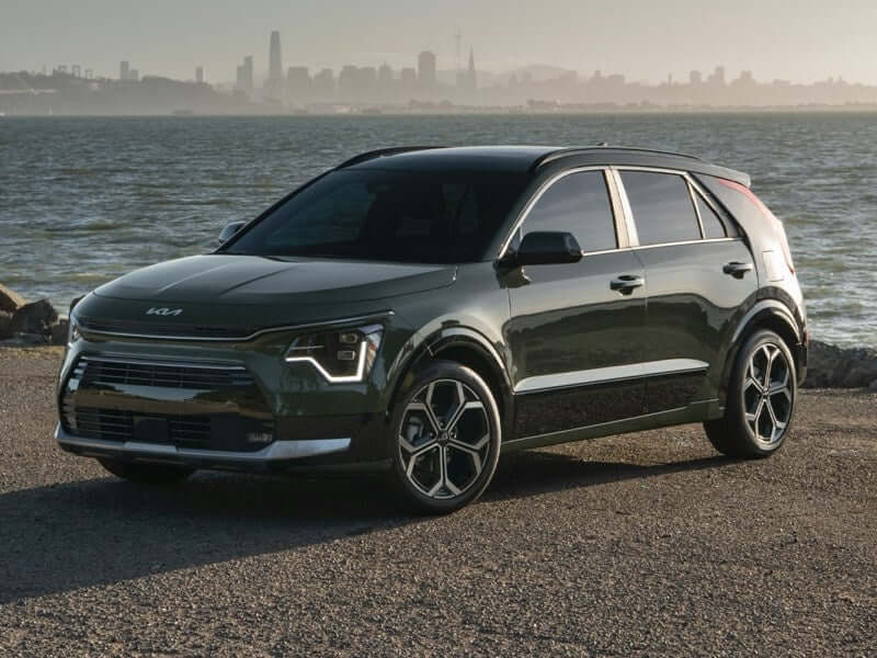 Dark green Kia Niro SUV parked near water.