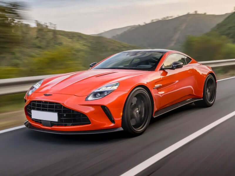 Orange sports car driving on a road.
